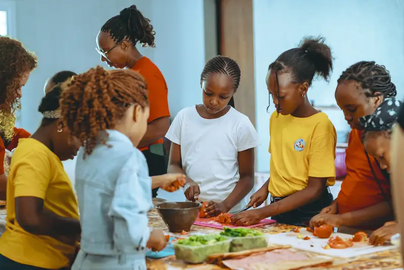 Des enfants coupent des légumes autour d'une table