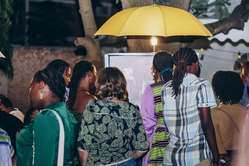 Le public regarde les photographies de l'exposition « 8 Regards », mars 2025