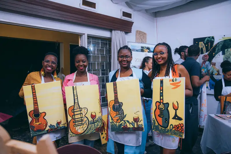 Quatre participantes montrent leurs toiles à la fin d'une soirée peinture