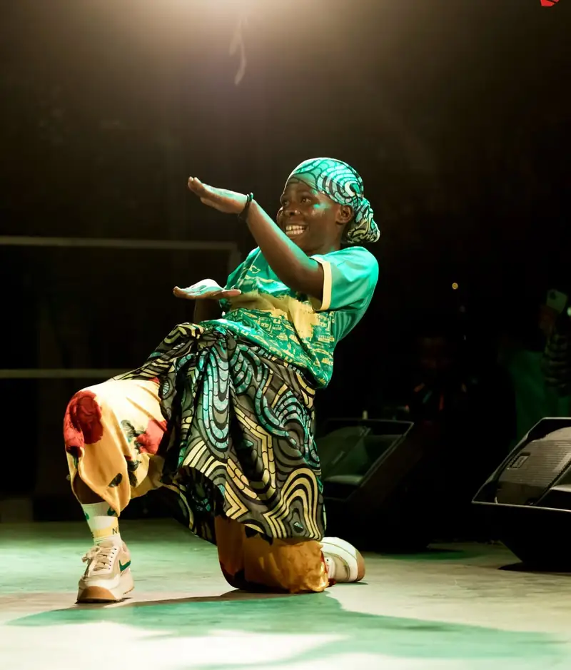 Une danseuse en tenue verte, un genou à terre, IZUBAFEST 2026