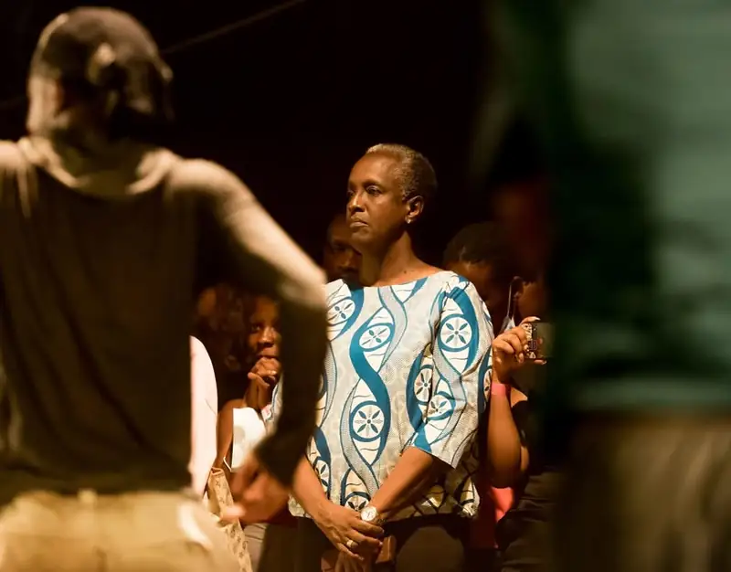 Lydia Nsekera, debout dans le public, regarde un danseur
