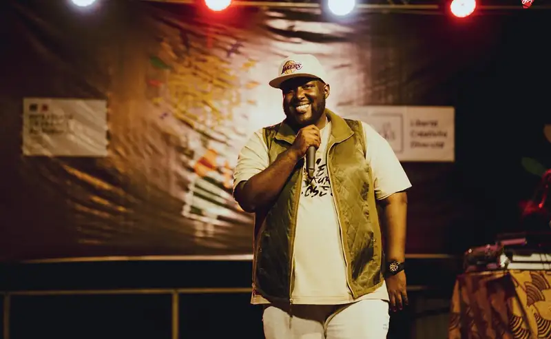 Un chanteur en gilet de cuir au micro, devant la scène
